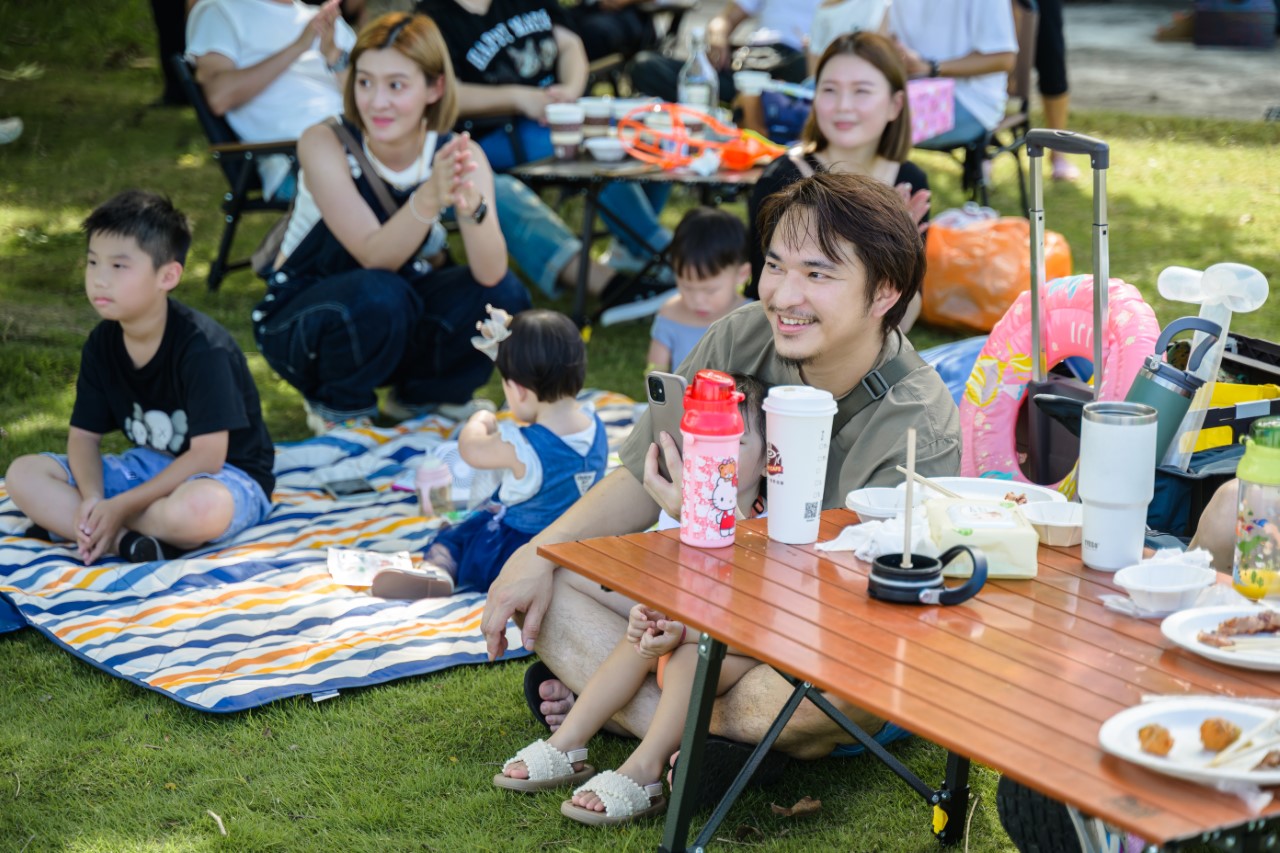 賓客們在草地上野餐看表演