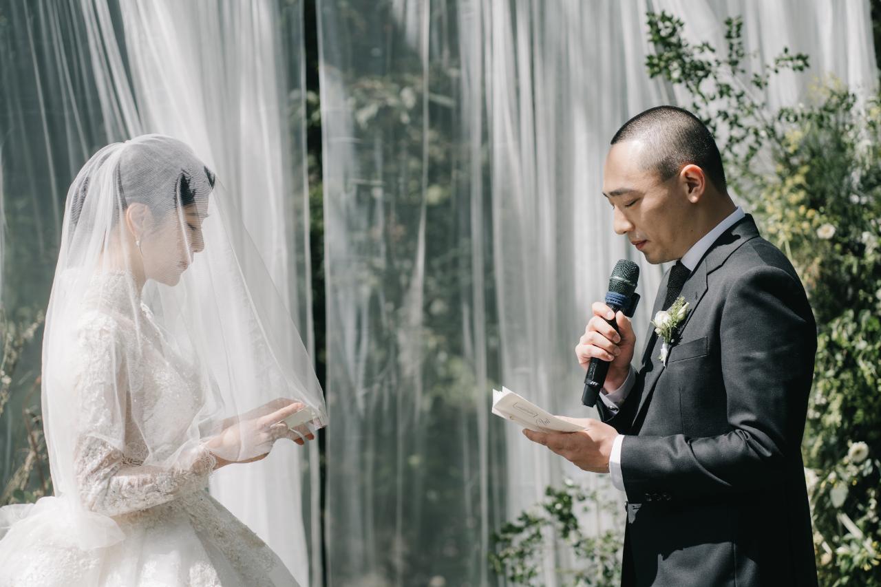 新人身穿白紗和西裝在山林中舉行證婚儀式