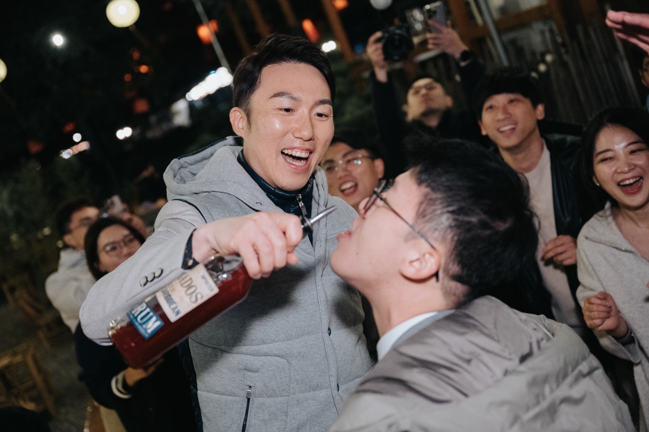 新郎於 after party 時拿著酒瓶為賓客灌酒，全場笑聲不斷，氣氛熱鬧歡騰
